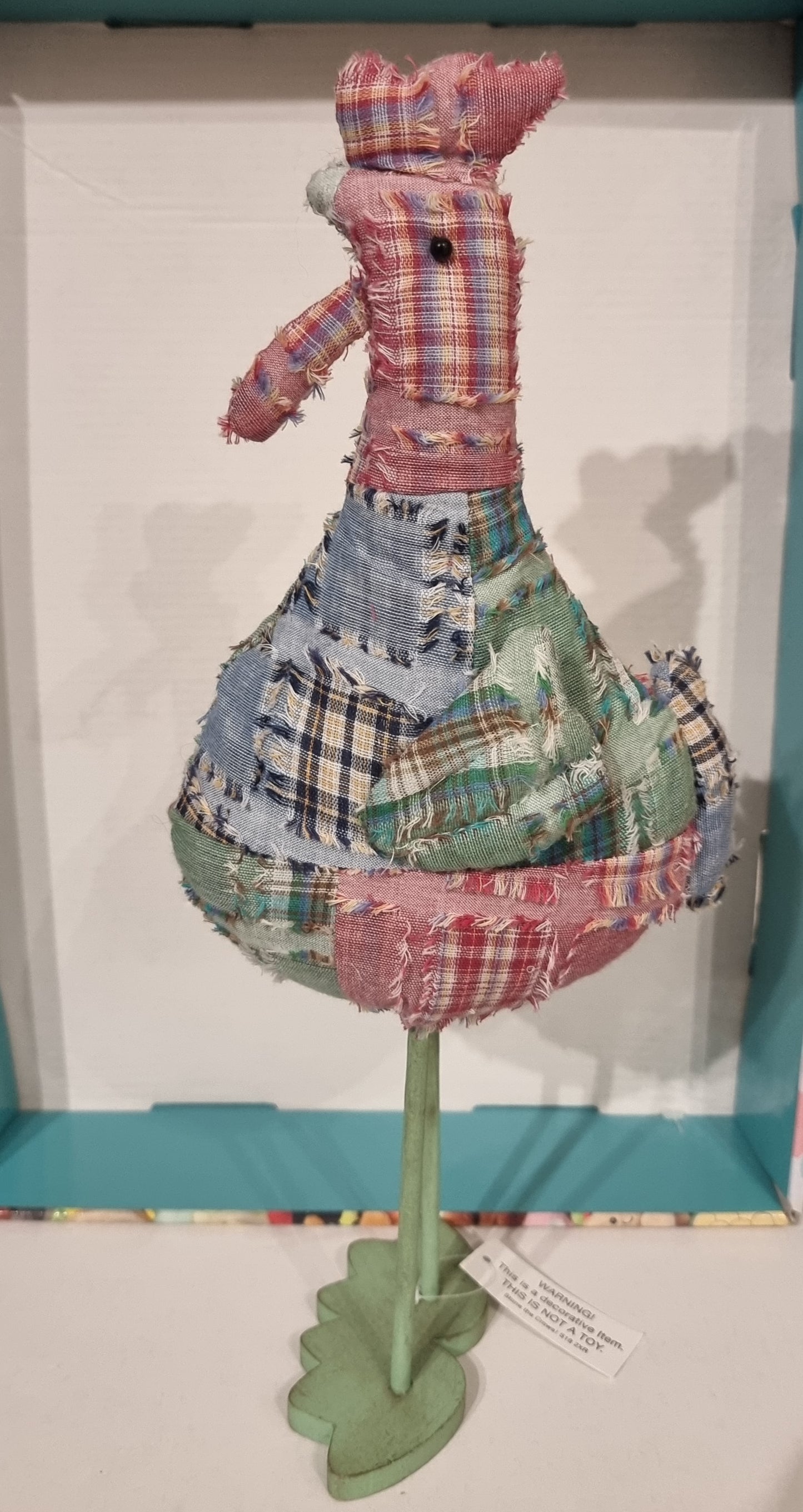 Patchwork stine the crows chicken figure on a stand with a white background
