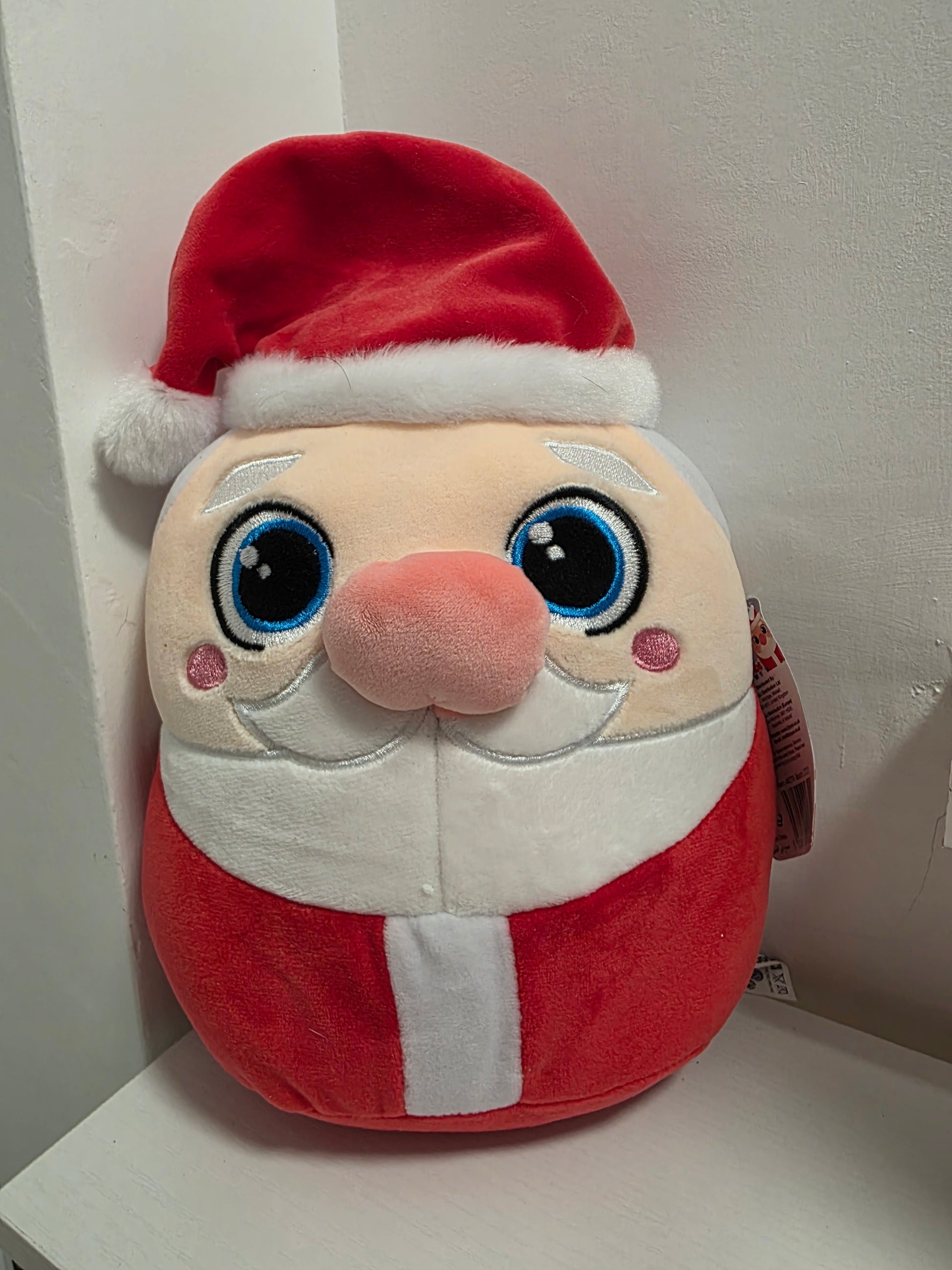Plush toy resembling a character with a red hat and white face on a white background