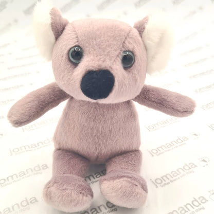 Plush koala toy with large eyes and a black nose on a white background with 'jomanda' branding.